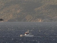 A Greek Coast Guard helicopter flies over a Frontex vessel trying to rescue refugees and migrants, after a boat carrying more than 200 people sunk while crossing part of the Aegean sea from Turkey