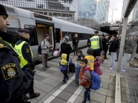 A group of migrants coming off an incoming train gather on the platform at the Swedish end of the bridge between Sweden and Denmark, in Hyllie district, Malmo